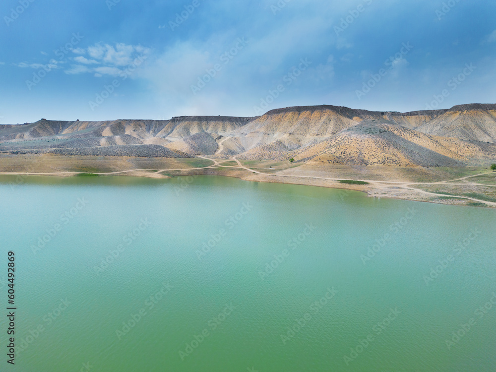 Aerial view on mountain lake. Drone view water reservoir at mountain valley. Beautiful view from above on smooth blue surface of mountain lake among highlands.