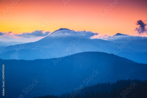 A majestic view of the mountain ranges illuminated by the sunset. © Leonid Tit