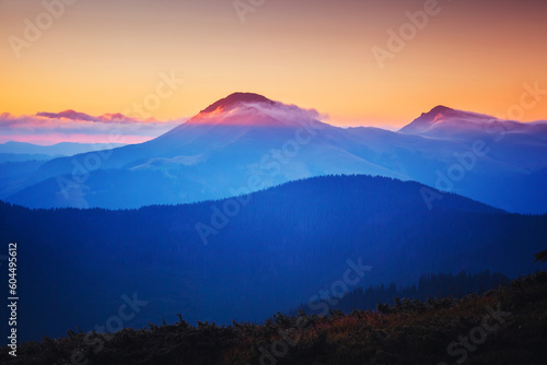 A majestic view of the mountain ranges illuminated by the sunset.