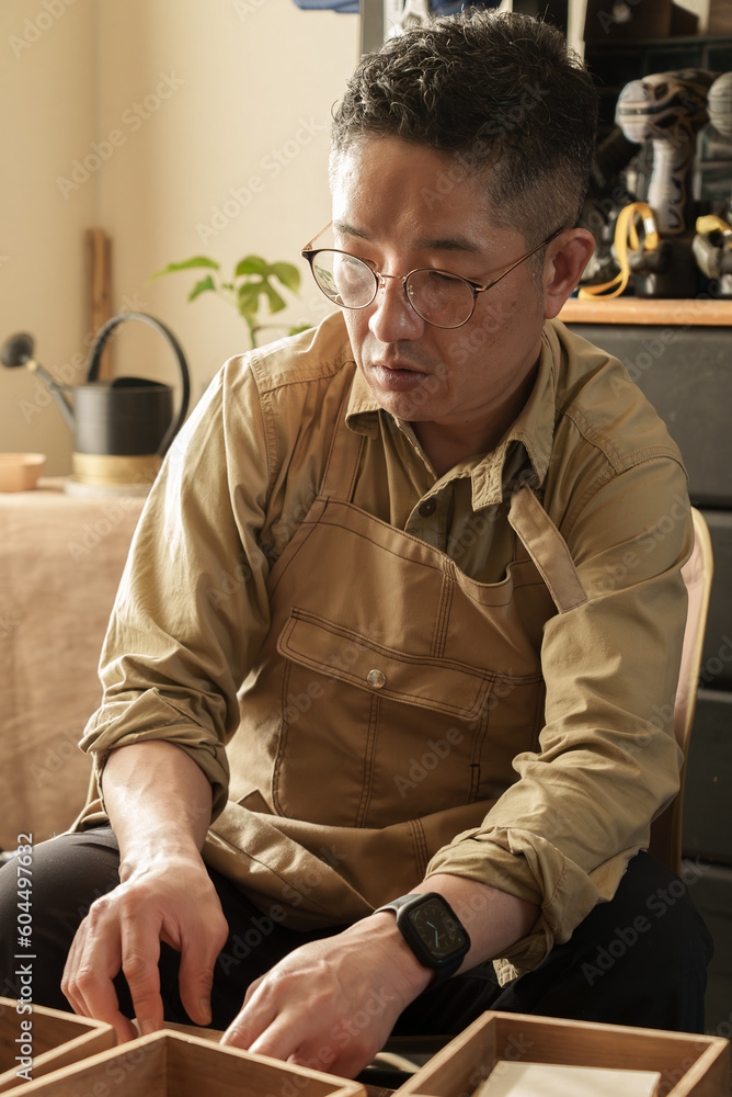 座って作業をする木工職人 座って作業をする木工職人