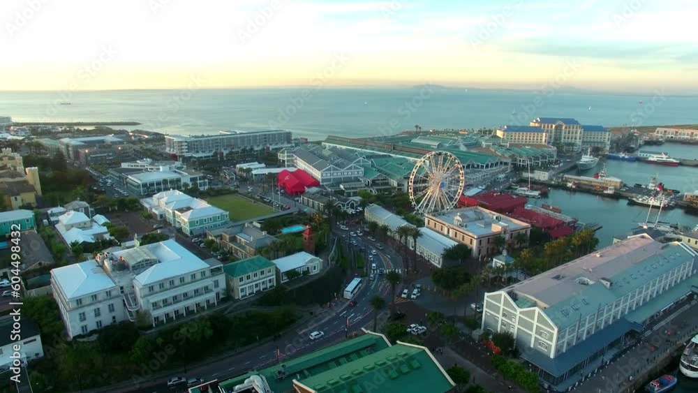 Sea, ferris wheel and travel with drone of cape town city buildings, a shopping mall and sunset. Ocean, tourism and landscape with harbor landmark attraction for retail, wow and skyline at coast Sea, ferris wheel and travel with drone of cape town city buildings, a shopping mall and sunset. Ocean, tourism and landscape with harbor landmark attraction for retail, wow and skyline at coast