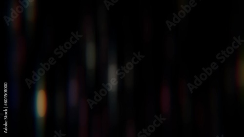 An anamorphic background of light leakage. Vertical spots of light flicker against a black background. photo