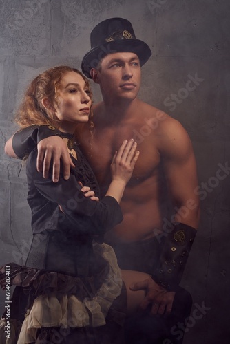 Stylish ethnic couple embracing in studio and looking at light