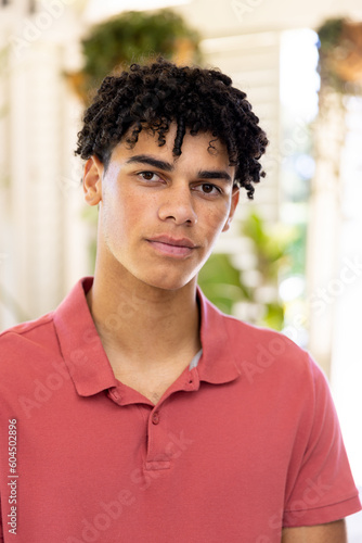 Close-up portrait of biracial young man with dreadlocks looking at camera at home, copy space