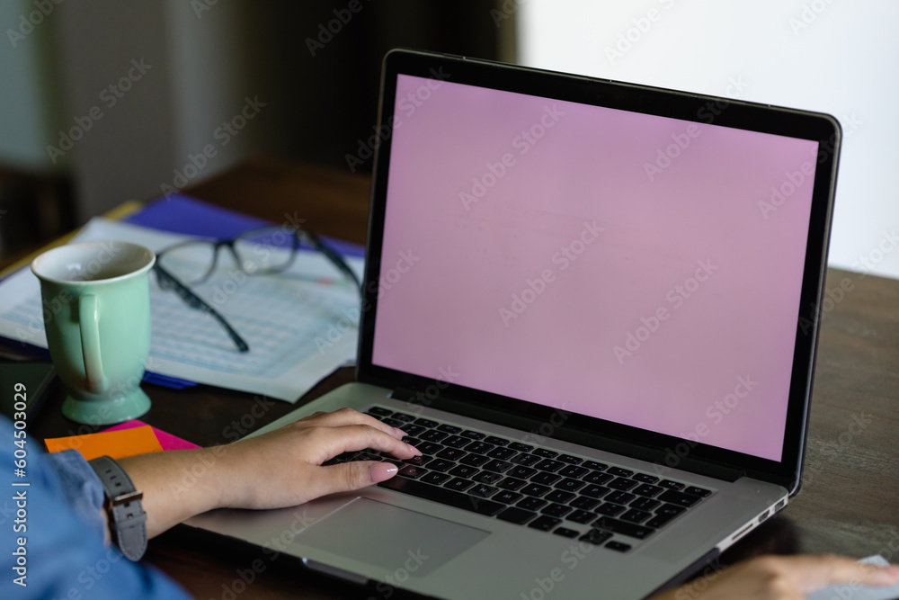 Hand of biracial woman using laptop with copy space on screen, working from home Hand of biracial woman using laptop with copy space on screen, working from home
