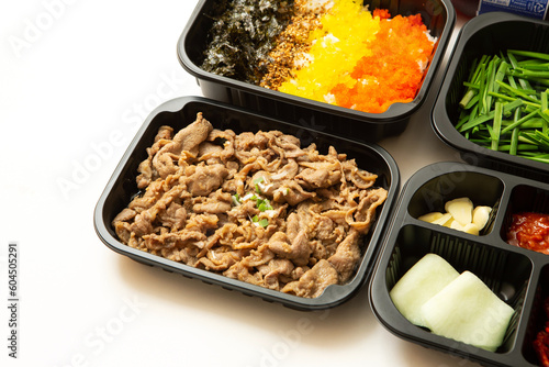 stir-fried meat and side dishes in a take-out container