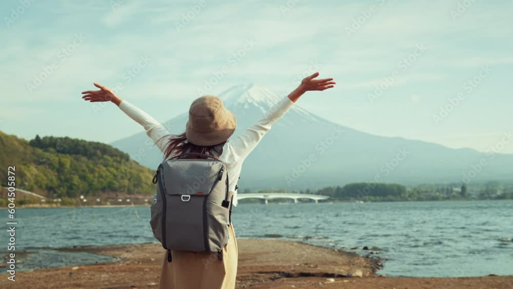 Back view of happy woman traveler enjoying with open arms in mountain Fuji view in bright day, Japan travel vacation, Freedom Back view of happy woman traveler enjoying with open arms in mountain Fuji view in bright day, Japan travel vacation, Freedom