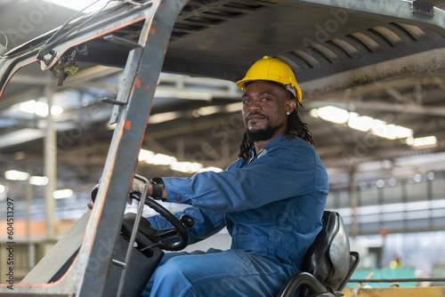 African american worker man wear safety helmet driver forklift warehouse in factory. Male worker industrial operate. control loading container box. logistics export import concept.