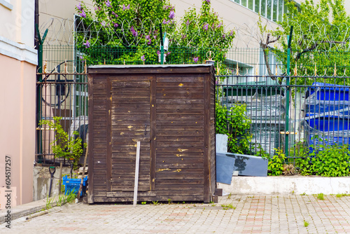 A wooden building near the building for horseradish cleaning equipment. The door is propped up with a stick. photo