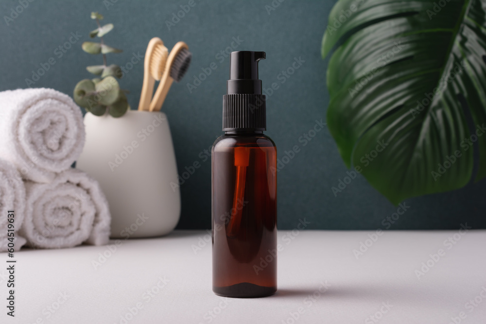 Cosmetic brown bottle with dispenser in minimal bathroom interior Cosmetic brown bottle with dispenser in minimal bathroom interior