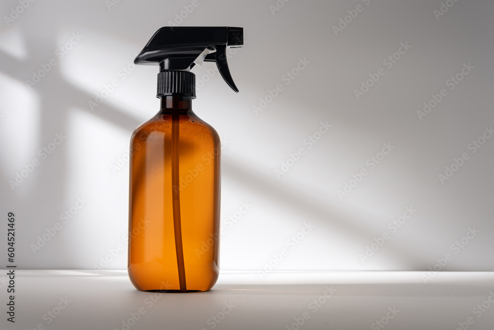 Single brown spray bottle on gray background with shadows Single brown spray bottle on gray background with shadows