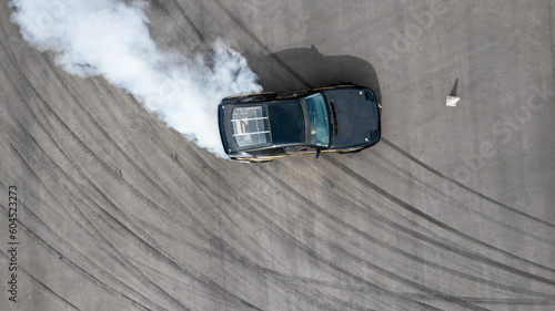 Aerial top view race car drifting on speed track, Professional driver drifting car on race track with smoke, Black tire tracks skid on asphalt road, Wheel tire tracks background.
