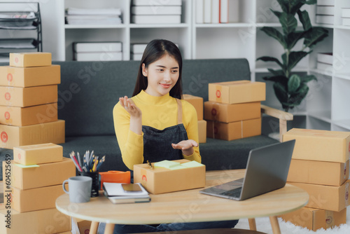 tarting Small business entrepreneur SME freelance,Portrait young woman working at home office, BOX,smartphone,laptop, online, marketing, packaging, delivery, SME, e-commerce concept © Kritdanai