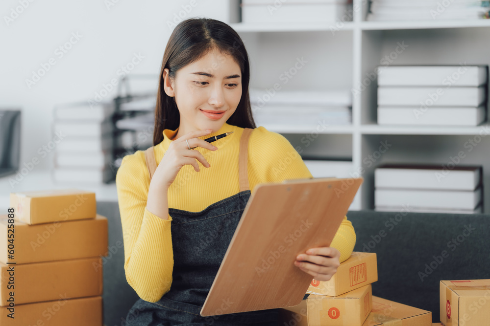 tarting Small business entrepreneur SME freelance,Portrait young woman working at home office, BOX,smartphone,laptop, online, marketing, packaging, delivery, SME, e-commerce concept tarting Small business entrepreneur SME freelance,Portrait young woman working at home office, BOX,smartphone,laptop, online, marketing, packaging, delivery, SME, e-commerce concept