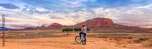 Woman on bike enjoying panoramic view of countryside land and mountain (Aragon, Spain)