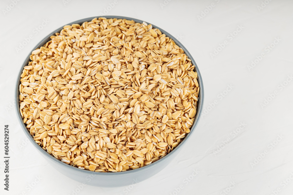Oat flakes bowl on a white background. Raw oatmeal for a healthy breakfast. Copy space. Top view Oat flakes bowl on a white background. Raw oatmeal for a healthy breakfast. Copy space. Top view