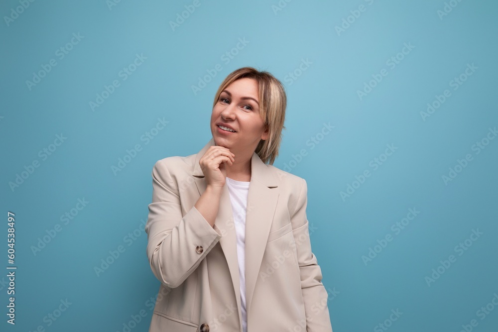 pensive blond millennial woman in stylish jacket thinks about business on studio background with copy space pensive blond millennial woman in stylish jacket thinks about business on studio background with copy space