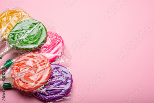 Lollipops wrapped on a pink background. Copy space.