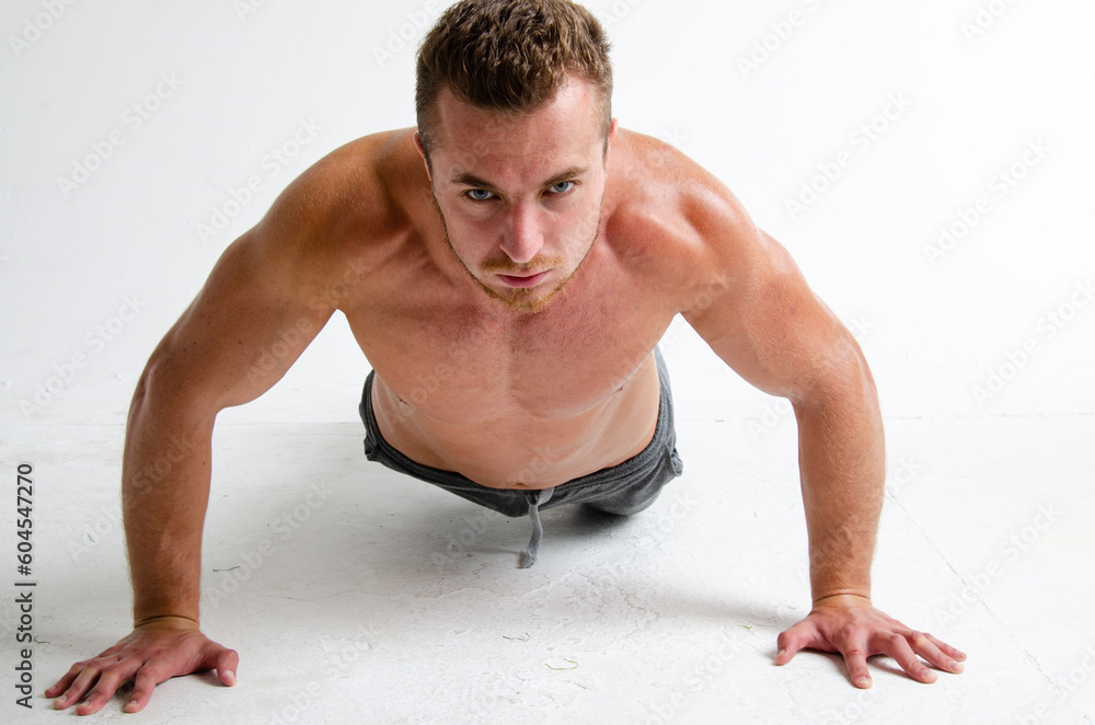 A young handsome guy does exercises on the abdominal muscles. A man with a beautiful athletic body. A young handsome guy does exercises on the abdominal muscles. A man with a beautiful athletic body.