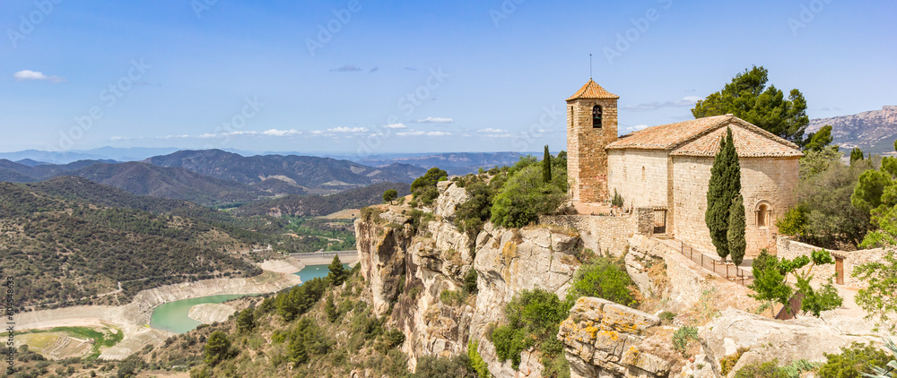 Panoramic view over the historic Santa Maria church and surrounding mountains in Siurana, Spain