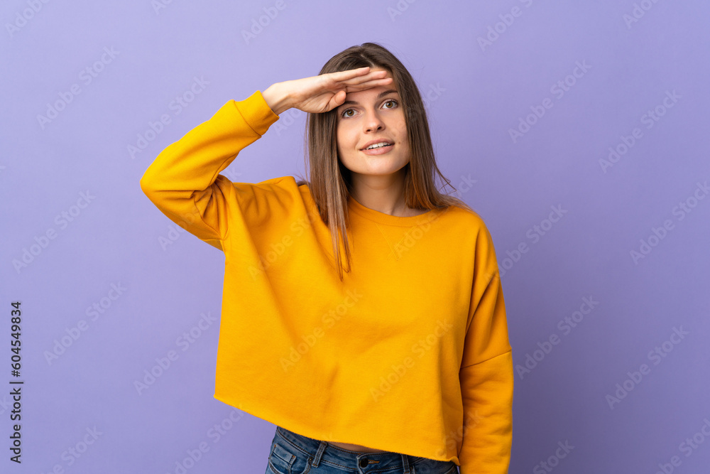 Young Slovak woman isolated on purple background looking far away with hand to look something Young Slovak woman isolated on purple background looking far away with hand to look something