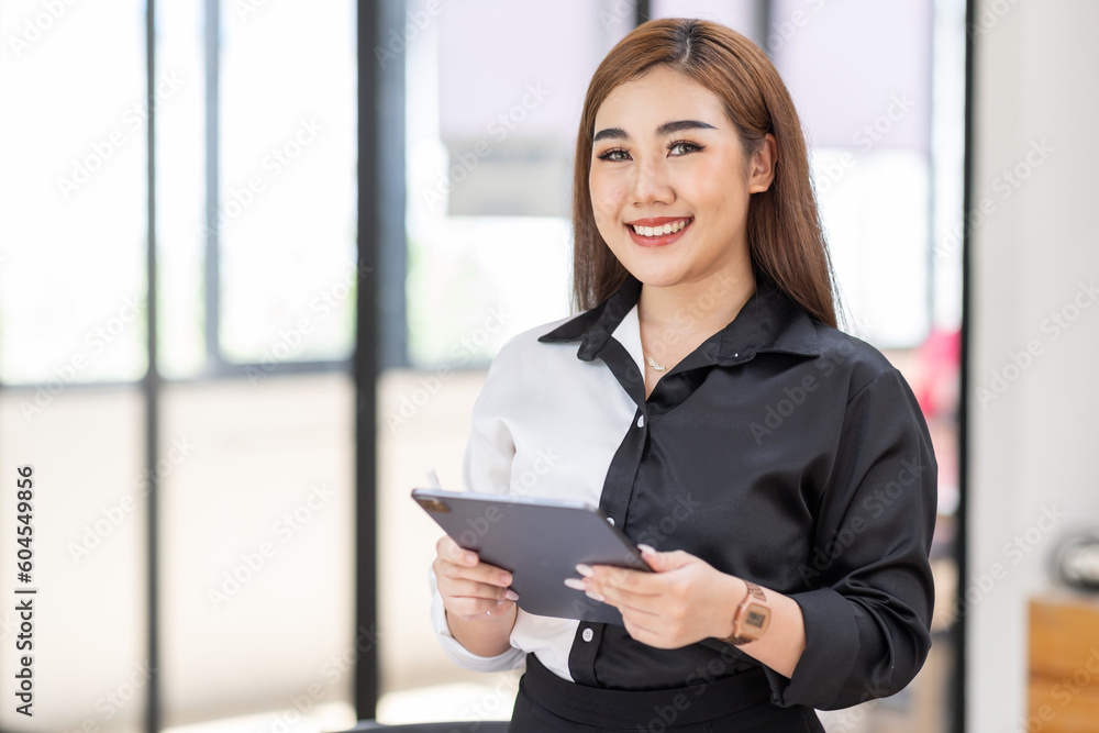 Portrait of Young business asian woman using tablet, standing in office.
Portrait of Young business asian woman using tablet, standing in office.