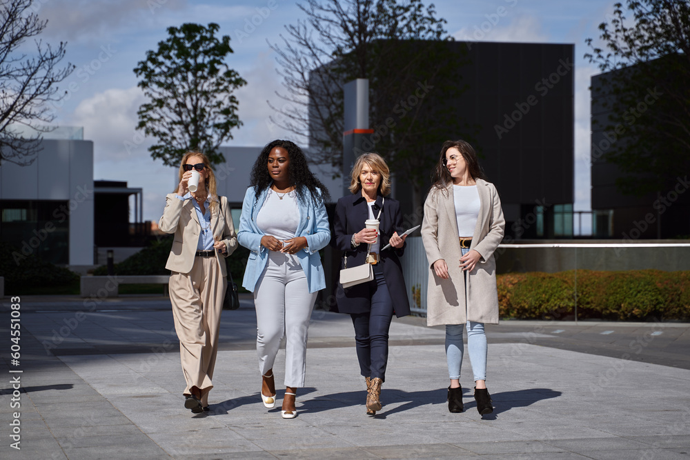 Fototapeta premium Professional and Confident Female Entrepreneurs Having a Productive Discussion While Strolling Through the Financial District, Symbolizing Success and Empowerment