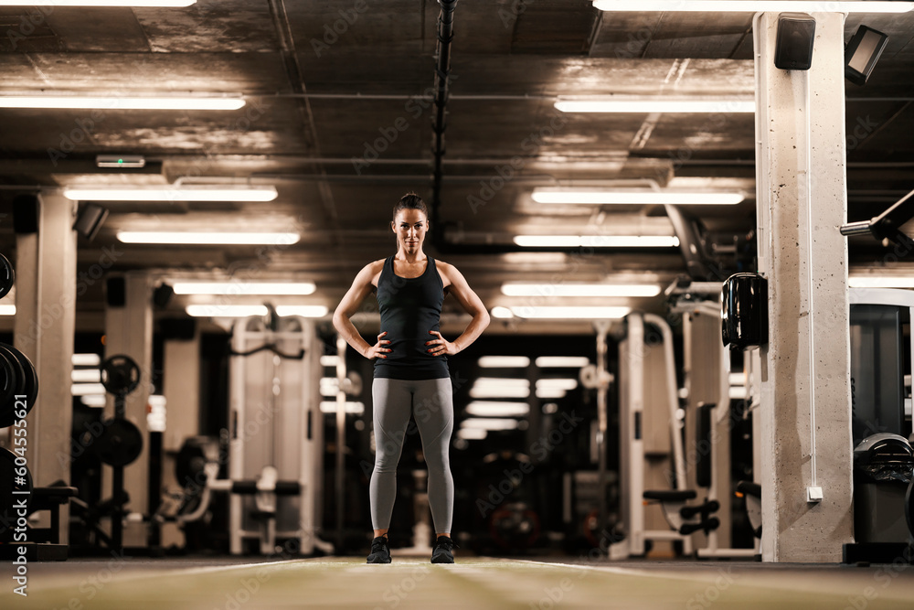 © Dusan Petkovic - Confident muscular sportswoman is standing in a gym.