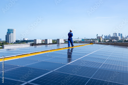 Engineers walking on roof inspect check and Maintenace solar cell panel by hold blue print ,solar cell is smart grid ecology energy sunlight alternative power factory concept.