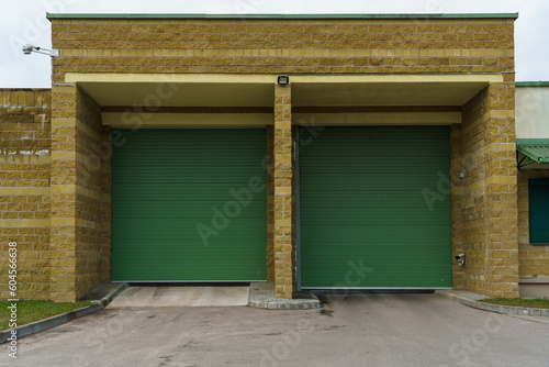 Large metal garage doors. Modern automatic garage door. Closed roller gates. Safe storage of the car.