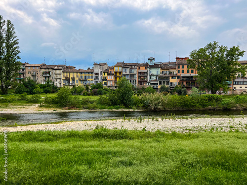 view of Parma with stream and profile of houses. meadow and sky.