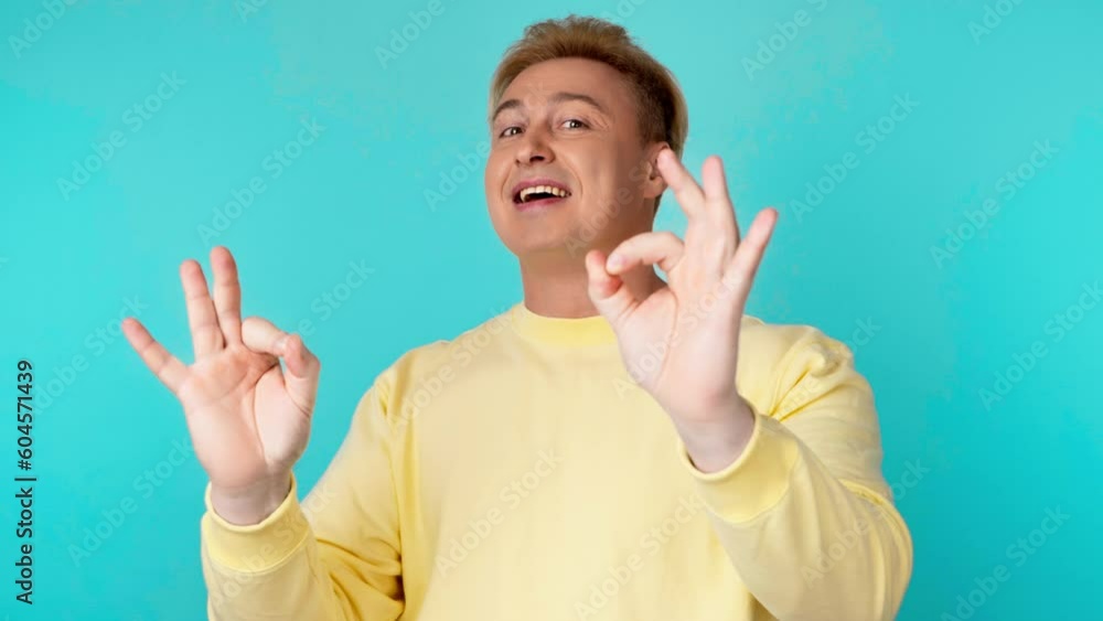 Man, ok hand, wink and smile excited emotion, sign or symbol feeling happy. Guy businessman with emoji okay gesture and mock up for success, approval, motivation or review, opinion on blue background Man, ok hand, wink and smile excited emotion, sign or symbol feeling happy. Guy businessman with emoji okay gesture and mock up for success, approval, motivation or review, opinion on blue background
