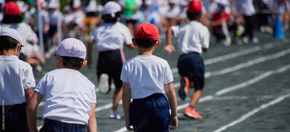 Fototapeta premium 小学校の運動会で短距離走をしている学生達の後ろ姿