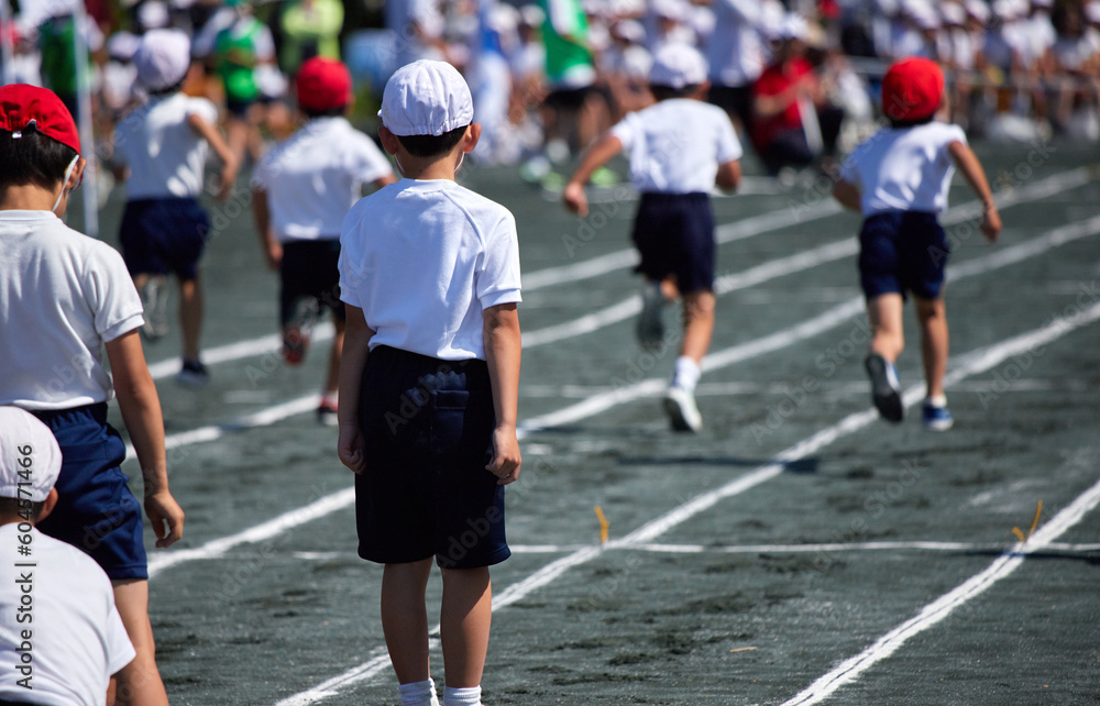 小学校の運動会で短距離走をしている学生達の後ろ姿