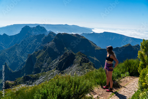 Beautiful tuorist woman stay on point of the island Madeira. View from Pico Ruivo in Madeira the highest in Portugal