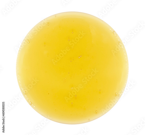 Foto A drop of oil or shampoo with small yellow bubbles on a white background