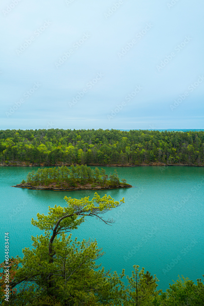 A small island with trees in Harpswell Cove over Cliff Trail, a hiking path landscape. Tranquil Maine coastal road seascape near Casco Bay and Orr’s Island on a foggy morning. 