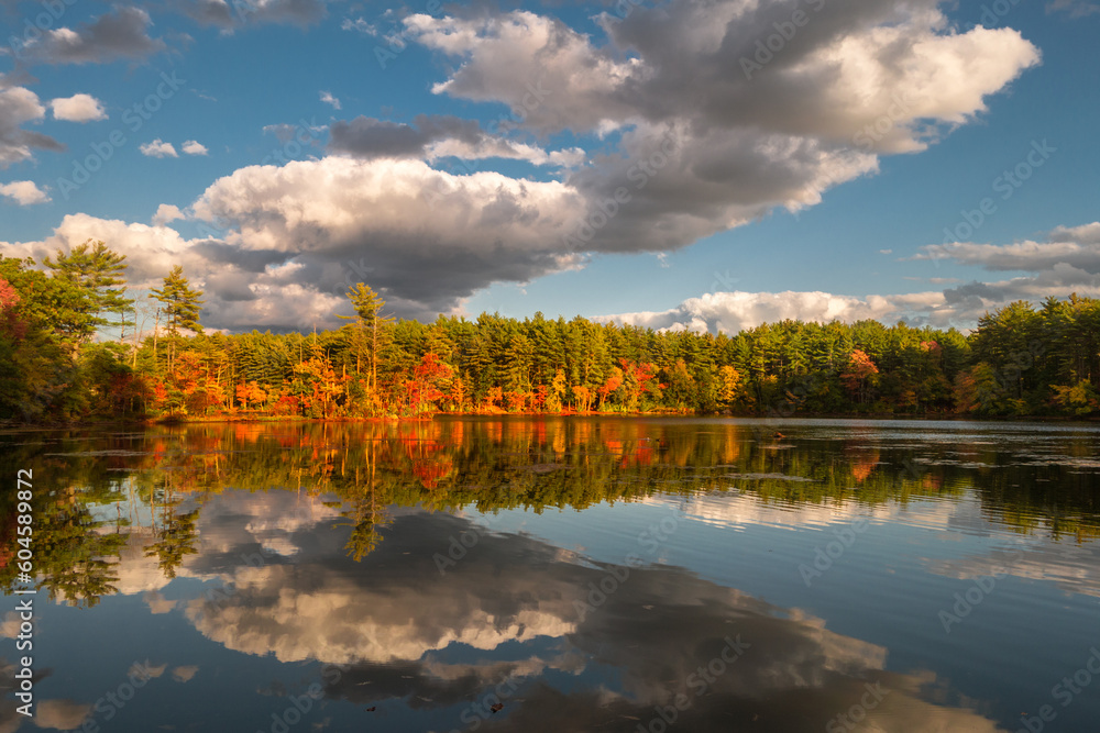  Fall foliage reflection in lake with dramatic clouds in sky.