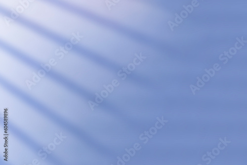 Abstract blue background with sun rays and shadow on the wall
