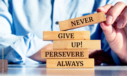 Quadro em tela Close up on businessman holding a wooden block with Never give up, persevere al