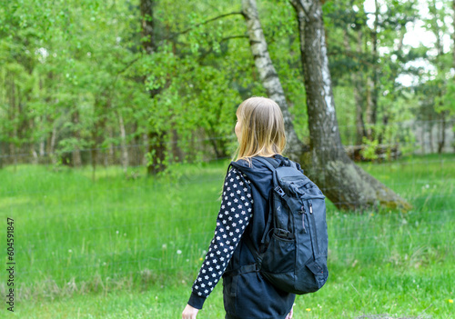 dziewczynka idzie do szkoły z dużym plecakiem na plecach