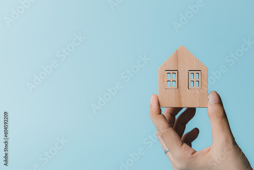 Hand holding a wooden house...