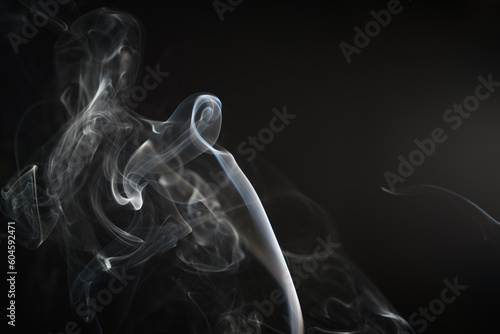 Siwe smugi zrobione z dymu z kadzidełka na ciemnym tle photo