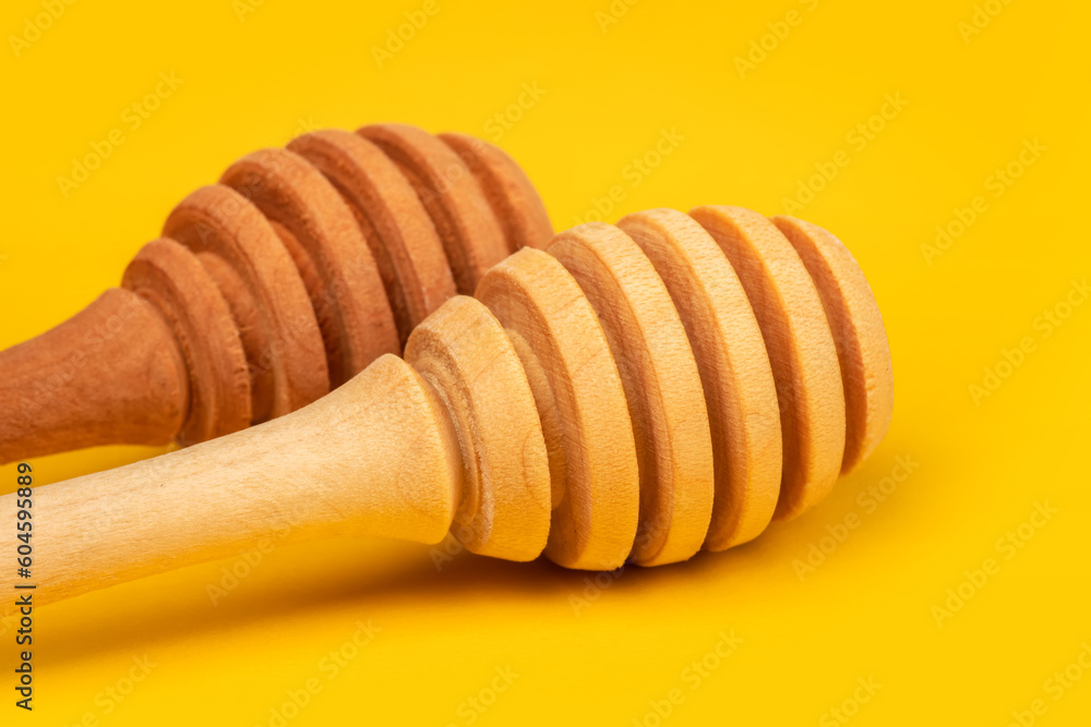 clean wooden honey spoon on yellow background clean wooden honey spoon on yellow background
