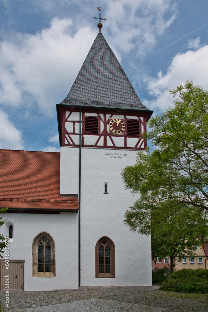 Seitliche Aufnahme einer Kirche in Mönsheim, Baden-Wuerttemberg, mit einer in Fachwerk eingelassenen Turmuhr