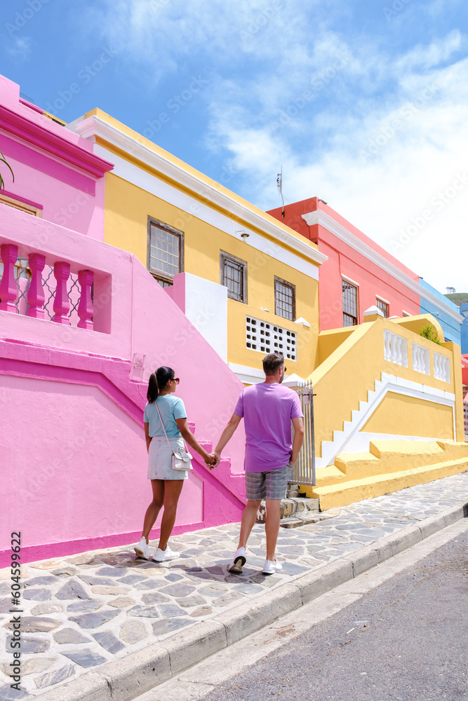 Naklejka premium Bo Kaap or Malay Quarter neighborhood a Colourful Street Township in Cape Town, is a colorful street with houses in South Africa. Bo Kaap, a couple of men and women on a city trip in Cape Town