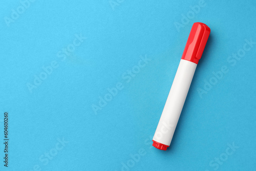 Bright red marker on light blue background, top view. Space for text