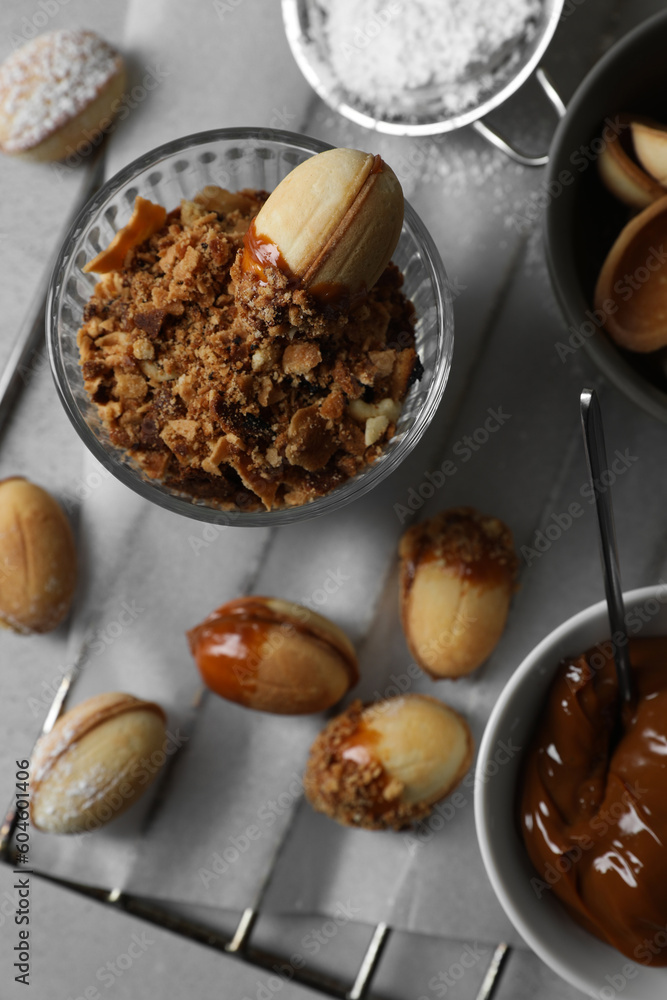 Fototapeta premium Delicious walnut shaped cookies with condensed milk on grey table, flat lay