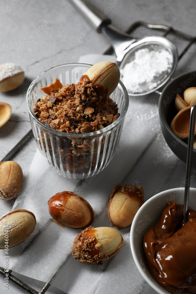 Fototapeta premium Delicious walnut shaped cookies with condensed milk on grey table, closeup