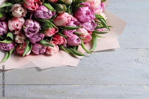 Bouquet of beautiful tulips on grey wooden table, closeup. Space for text